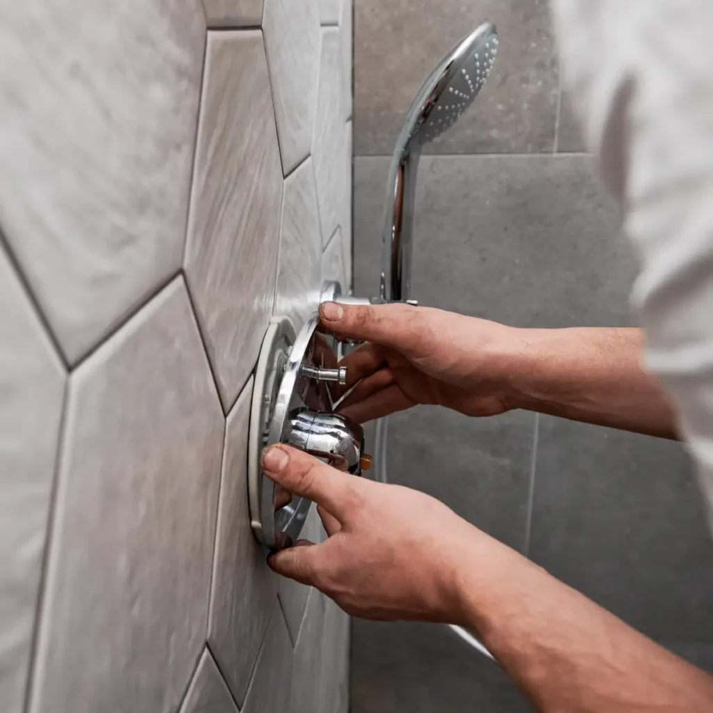 chinook plumbing plumber installing faucet in a shower